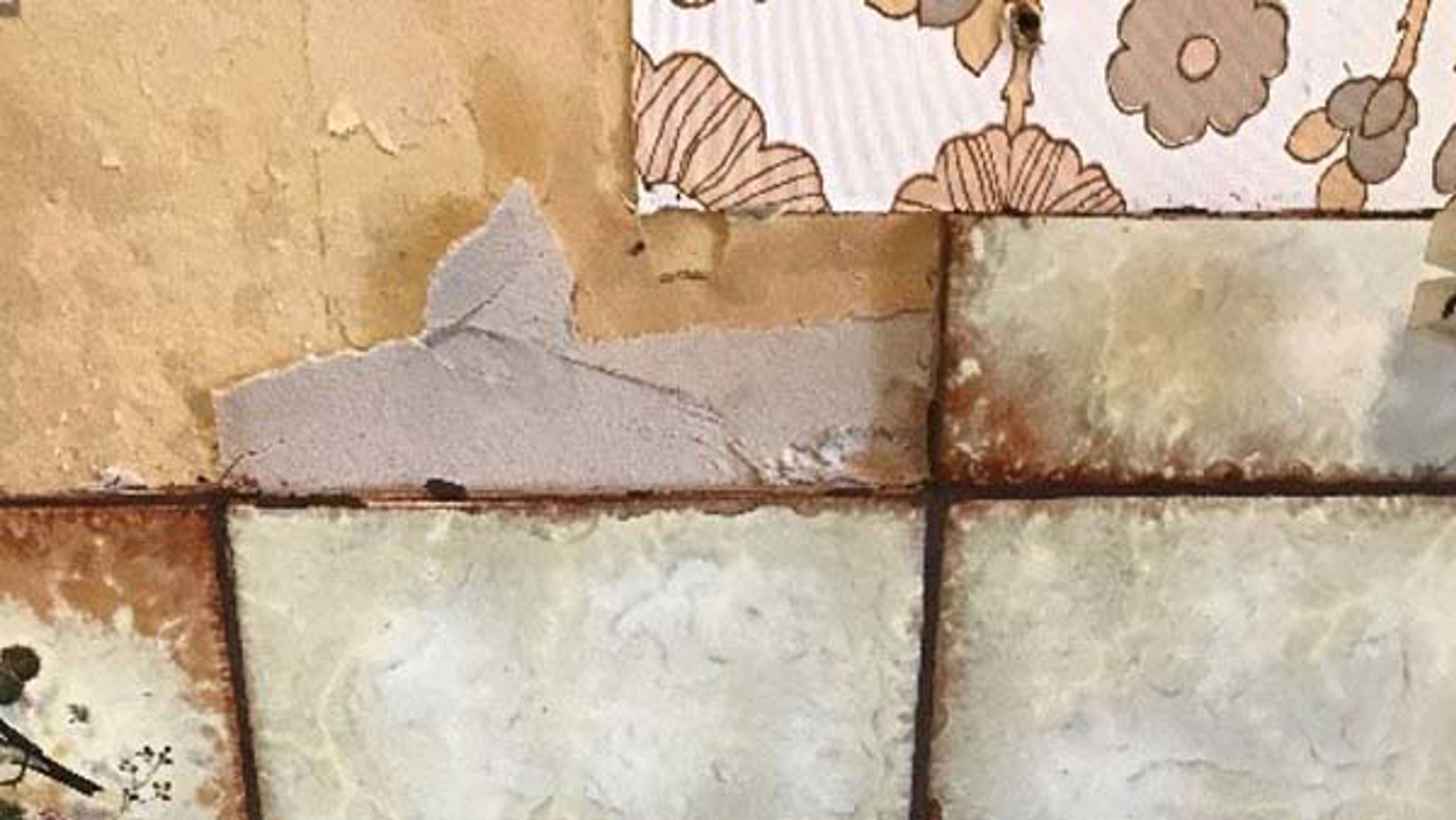 Bildet viser gamle veggfliser som delvis er revet av. En grå masse med asbestholdig fliselim er festet til veggen der noen av flisene er fjernet.